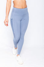 Load image into Gallery viewer, Shakolo mid rise leggings in blue front view with one leg forward
