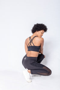 Shakolo crossover bra in black and mid waist leggings in black back view model squating