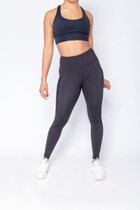 Shakolo crossover bra in black and mid waist leggings in black front view model leaning to the side