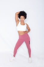 Load image into Gallery viewer, Shakolo crossover bra in white and high waist leggings in pink front view model with one hand behind head and other arm on waist